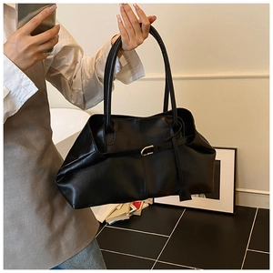 Détails du sac cabas en cuir ciré noir avec une boucle décorative et texture plissée