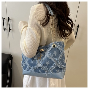 Dettaglio borsa in denim azzurro con stelle, catena dorata e ciondolo a forma di cervo