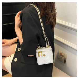 Detailansicht der weißen Mini-Box-Tasche mit Schlangentextur und goldener Kette