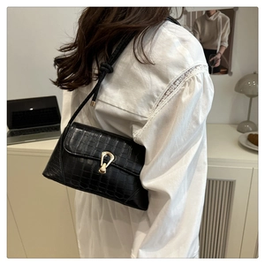 Sac sous le bras tendance à motif crocodile noir avec boucle métallique sur un modèle