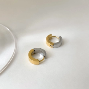 Détail de boucles d'oreilles C épaisses bicolores or et argent avec fini métallique mat