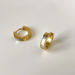 Gros plan sur des boucles d'oreilles dorées en C avec nacre blanche et détails zircons