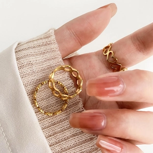 Détails de bagues dorées empilables avec motifs cœurs ajourés et facettes au doigt