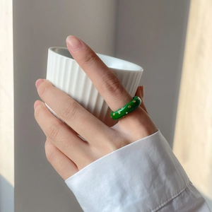 Bague vintage en émail vert avec cristaux, portée par un mannequin tenant une tasse
