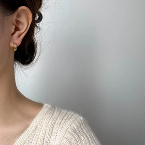 Élégantes boucles d'oreilles créoles dorées en C avec zircons sur un mannequin