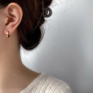 Boucles d'oreilles en C dorées avec incrustation de nacre sur un mannequin style chic