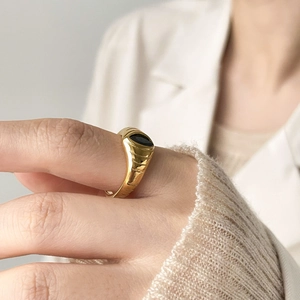 Détail d'une bague vintage en or nervuré avec une pierre précieuse ovale noire