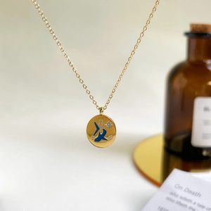 Detail of gold titanium steel necklace with blue enamel nautic coin pendant and symbols