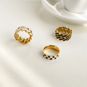 Three gold fashion rings with black and white checkerboard enamel and chain design