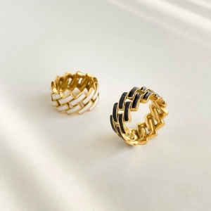 Detailed view of gold chain link rings with black and white checkerboard enamel