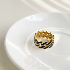 Detailed macro view of the gold chain ring with black enamel checkerboard tiles