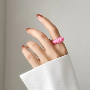 Detail of pink croissant ring with twisted texture worn on hand for French retro style
