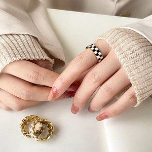 Golden rings set with black and white checkerboard enamel and chain hollow pattern