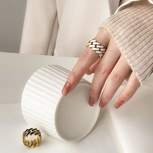 Detail of gold Cuban chain rings with black and white enamel checkerboard design