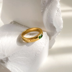 Minimalist gold wide band ring featuring an oval emerald green zircon stone