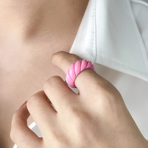Close-up of pink croissant ring with glossy resin finish on model's finger