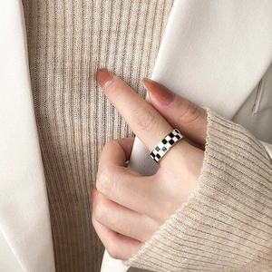 Modern gold checkerboard enamel ring for women shown on index finger with a stylish look