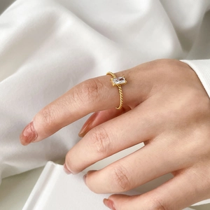 Vue détaillée d'une bague en zircon rectangulaire avec anneau torsadé doré