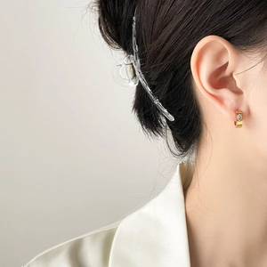 Elegante goldene Creolen mit ovalen Zirkonia und Fächermuster an einem stylischen Modell