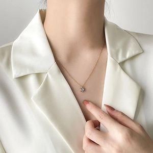 Minimalist gold necklace featuring a classic round 1-carat zircon pendant on a model