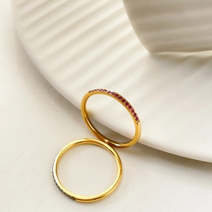 Close-up of gold-plated titanium steel rings with a row of sparkling red zircons