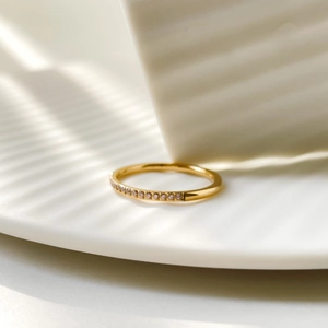 Macro detail of gold-plated titanium ring with multi-color zircon stones and stripe shadows