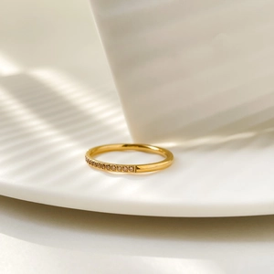 Macro shot of gold-plated titanium ring with sparkling zircons and striped shadows