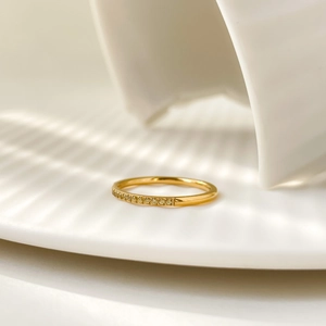 Macro view of gold-plated titanium ring with sparkling clear zircon pavé setting