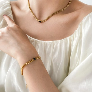 Détail de l'ensemble collier et bracelet à mailles gourmettes avec cœurs noirs élégants