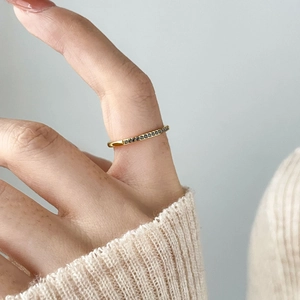 Close-up of thin gold plated titanium ring with rows of small black zircon gemstones