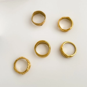 Détail d'un lot de 5 bagues dorées aux textures géométriques et style minimaliste