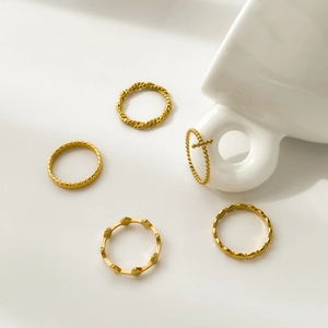 Detailed set of five gold geometric rings featuring twisted textures and a cross charm