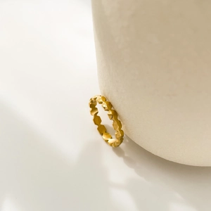 Detailed close-up of a minimalist gold ring with geometric honeycomb faceted textures