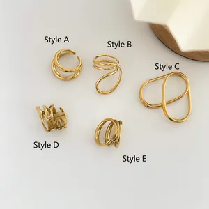 Vue de dessus de cinq bagues dorées minimalistes avec cœur ajouré et formes géométriques
