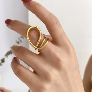 Détail d'une bague coeur creuse abstraite multicouche avec lignes spirales dorées