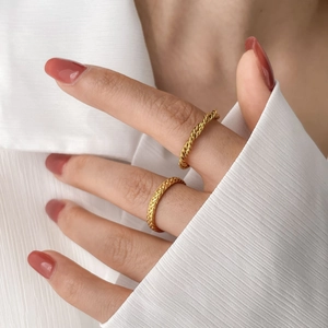 Close-up of gold woven and twisted rings showcasing intricate geometric textures