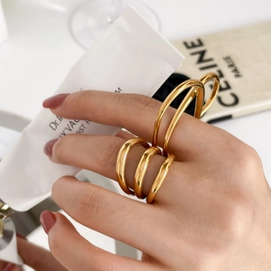 Détail d'une bague multicouche dorée minimaliste au design abstrait de cœur évidé