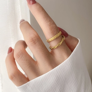 Detail view of two vintage gold braided rings with twisted rope and wheat patterns
