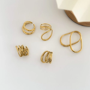 Vue à plat de bagues dorées artistiques aux formes abstraites et designs ondulés multicouches
