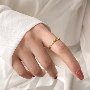 Close-up of a minimalist golden geometric faceted ring on model finger for elegant look