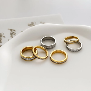 Detailed view of gold and silver eternity rings with channel-set square zircons on ceramic
