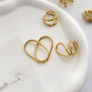 Bagues dorées artistiques et bijoux coeur ajouré sur un plateau en céramique