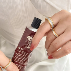 Close-up of golden titanium steel rings with channel-set rectangular zircon stones
