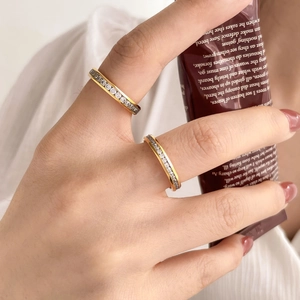 Detail of model wearing gold-plated stackable rings with sparkling white crystals