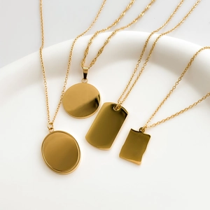 Polished 18k gold plated titanium necklaces with sun, star and moon pendants on a tray