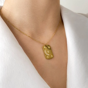 Detailed close-up of a 18k gold plated sun medallion necklace featuring moon and star engravings