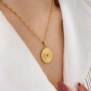 Detail of 18k gold plated titanium sun medallion necklace with star and moon motif