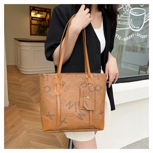 Détail du sac cabas vintage marron avec imprimés et charm assorti dans un café décor