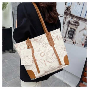 Detailed side view of vintage monogram tote bag with matching mini card holder charm