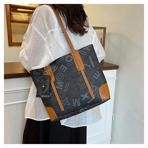 Détail du sac cabas gris à motifs avec garniture en cuir marron et pochette assortie